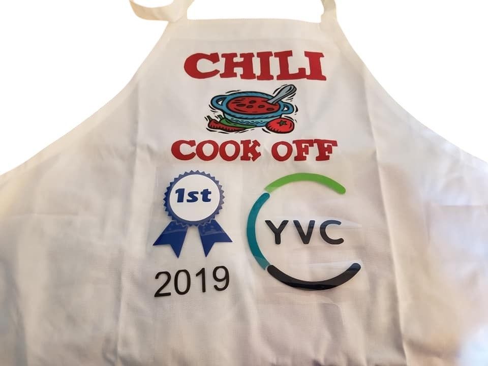 A white apron that says chili cook off on it