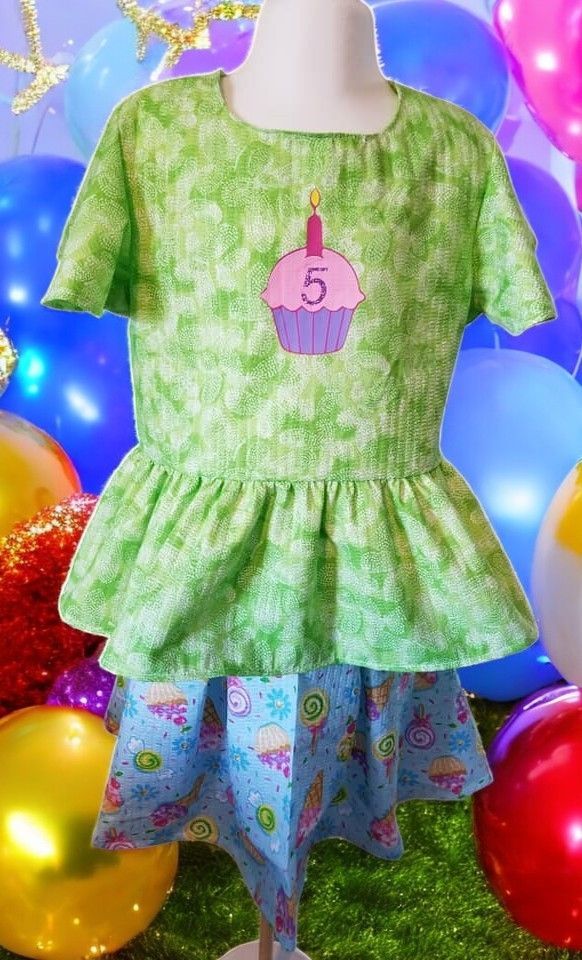 A green shirt with a pink cupcake with the number 5 on it
