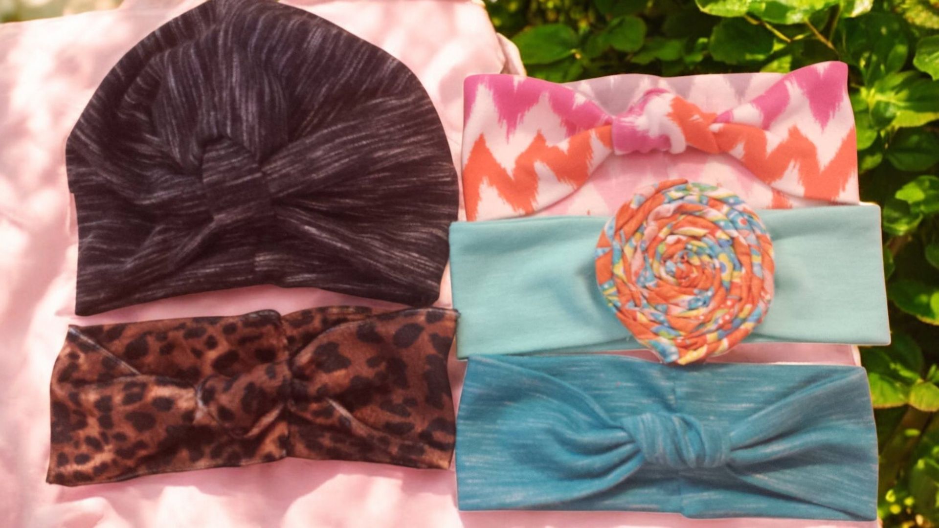 A bunch of headbands are stacked on top of each other on a pink surface.