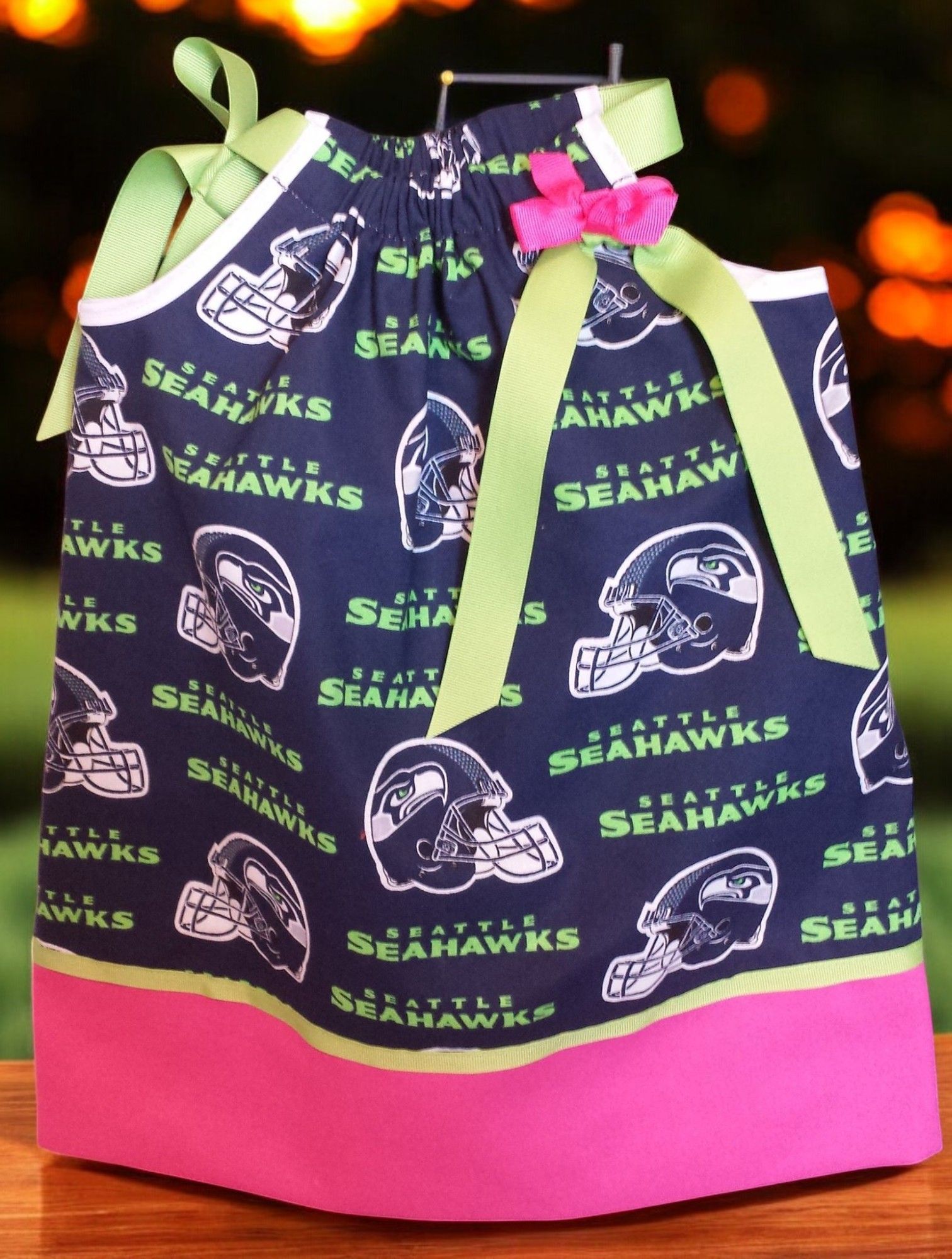 A little girl 's dress with seattle seahawks on it