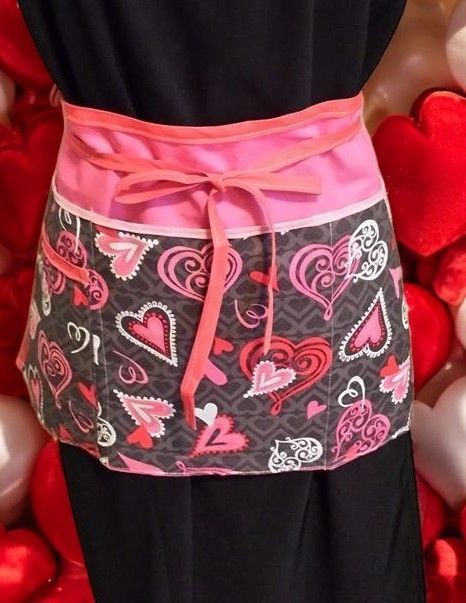A woman wearing an apron with hearts on it