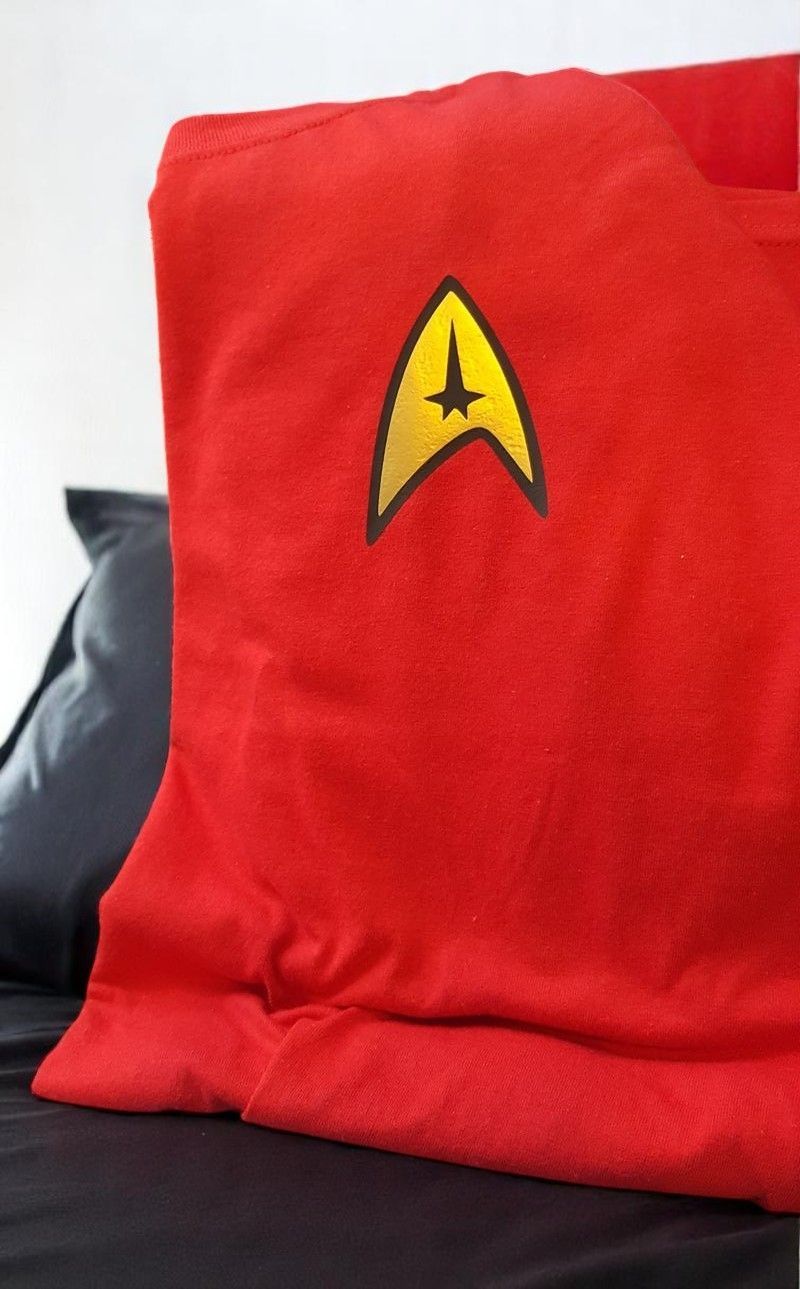 A red shirt with a yellow star trek logo on it