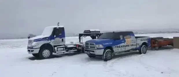 A row of modular white office container buildings along a narrow, unpaved path under a cloudy sky.