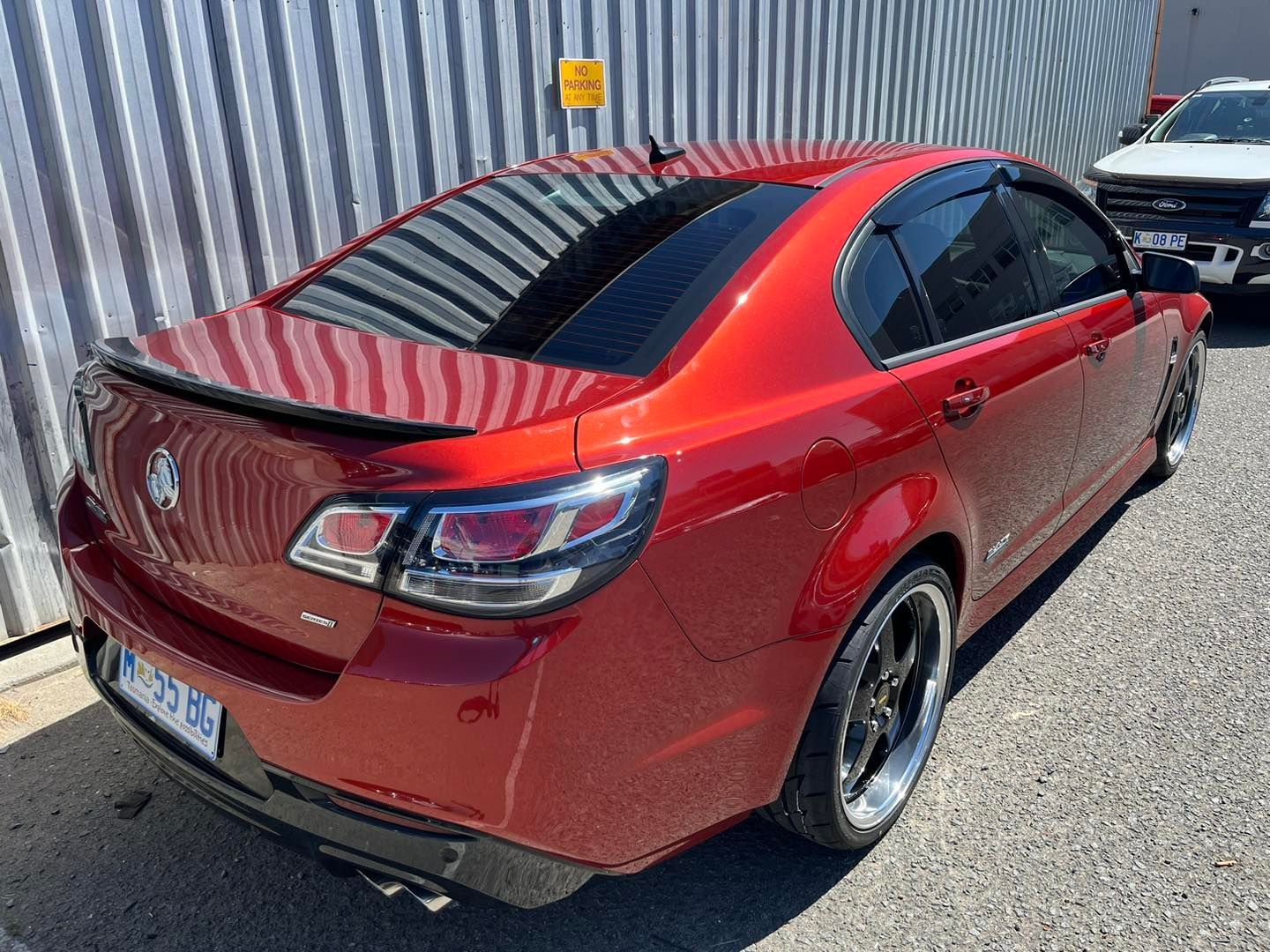 A Shiny Red Holden Commodore Sedan Parked on a Gravel — Magic Tintz in Moonah, TAS