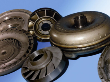 Piezas de transmisión de automóvil metálicas, dispuestas sobre un fondo degradado azul.