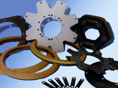 Varias piezas mecánicas, incluidos engranajes y acoplamientos, dispuestas sobre un fondo azul.