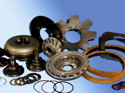 Piezas de transmisión de automóvil dispuestas sobre un fondo degradado azul, mostrando varios componentes metálicos.