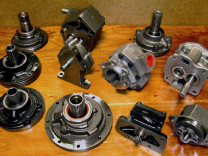 Bombas hidráulicas y componentes expuestos sobre una superficie de madera.