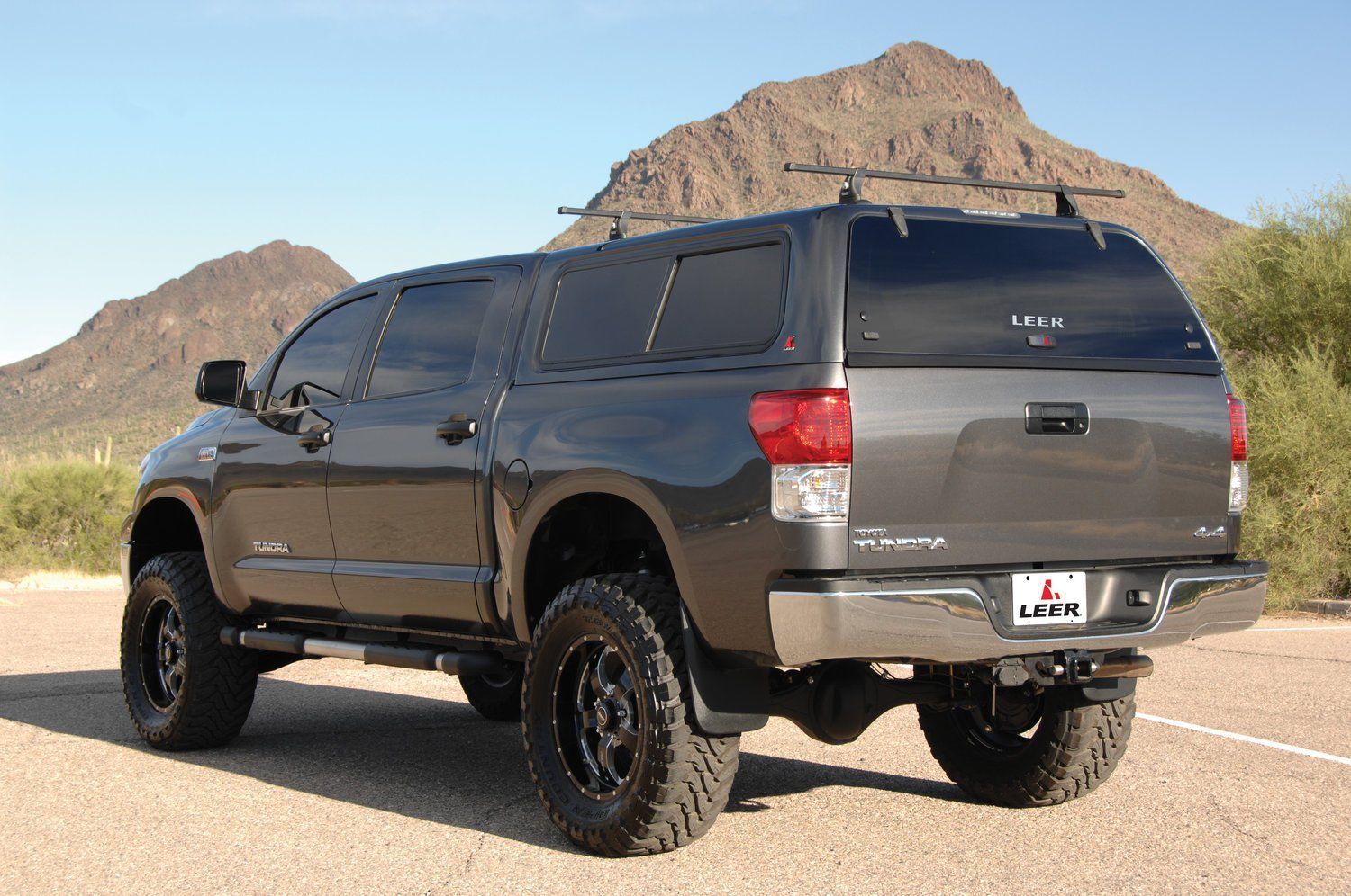 A toyota tundra is parked on the side of the road in front of a mountain.