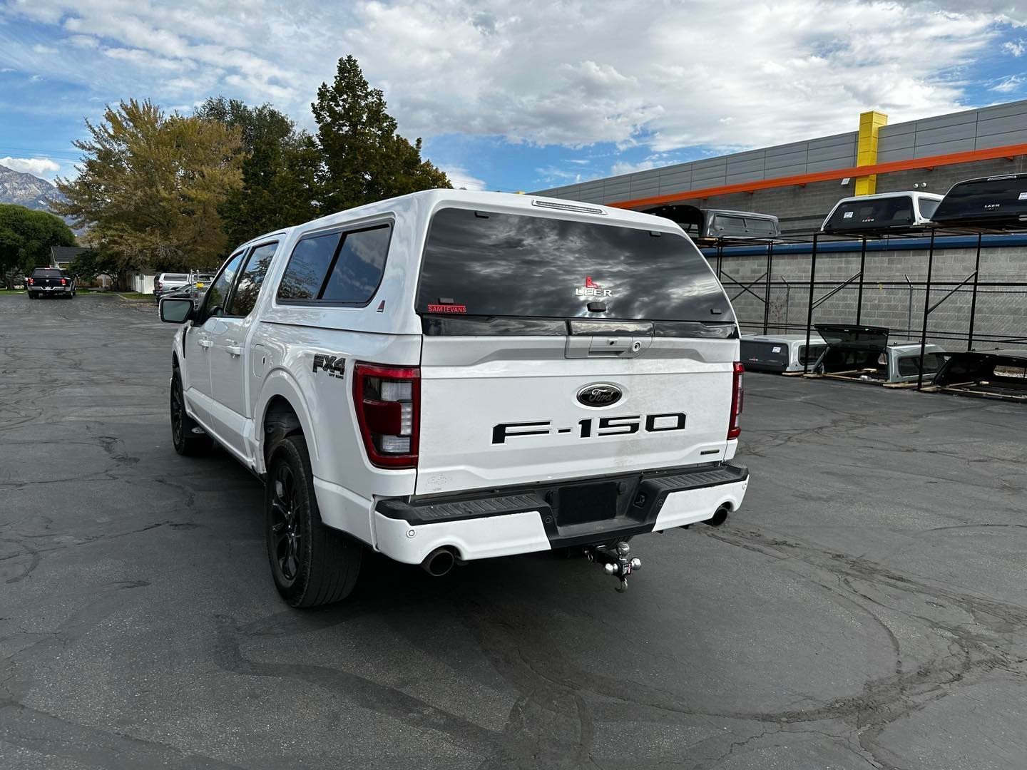 A white ford f150 truck is parked in a parking lot.