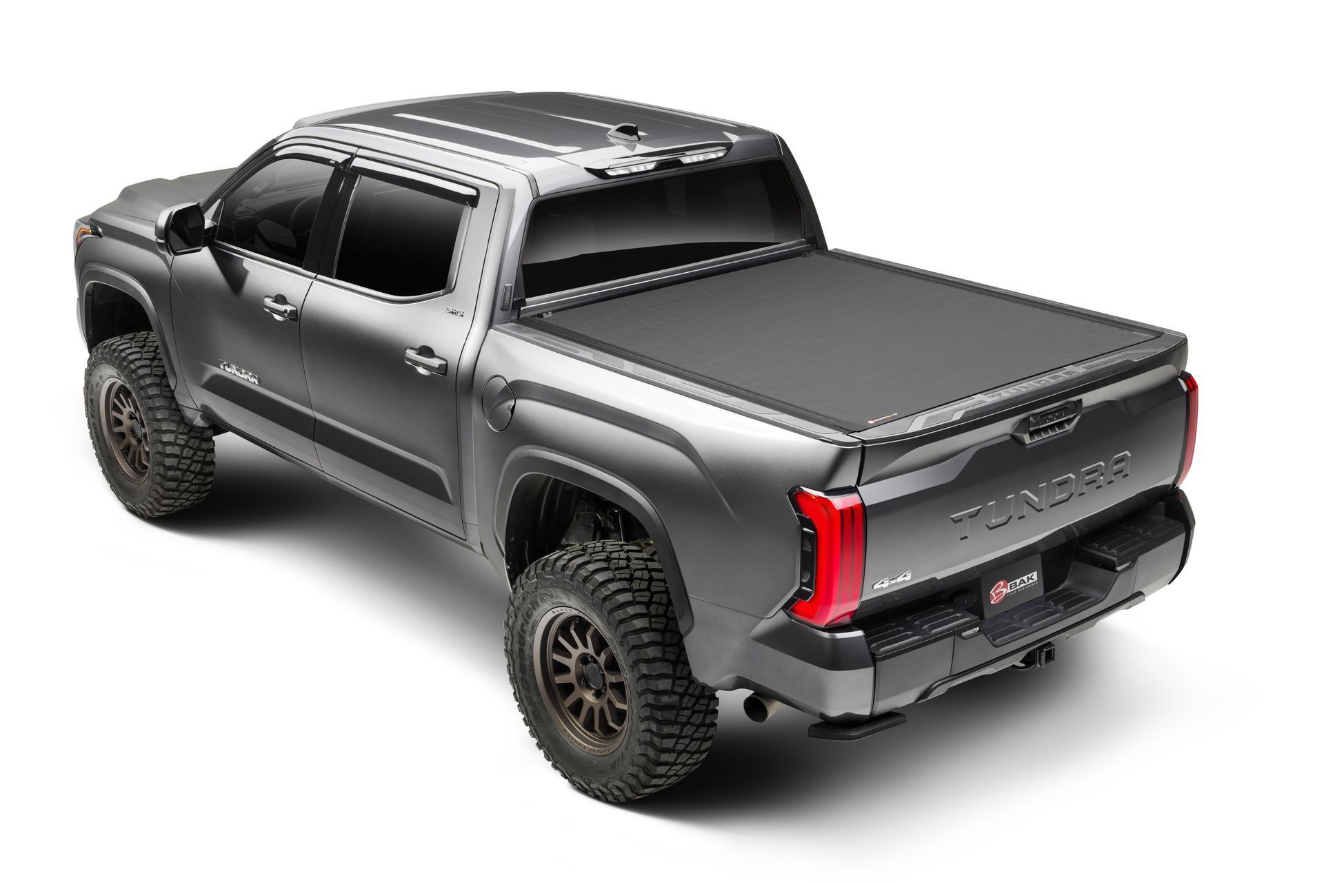 A toyota tundra with a black bed cover on a white background.