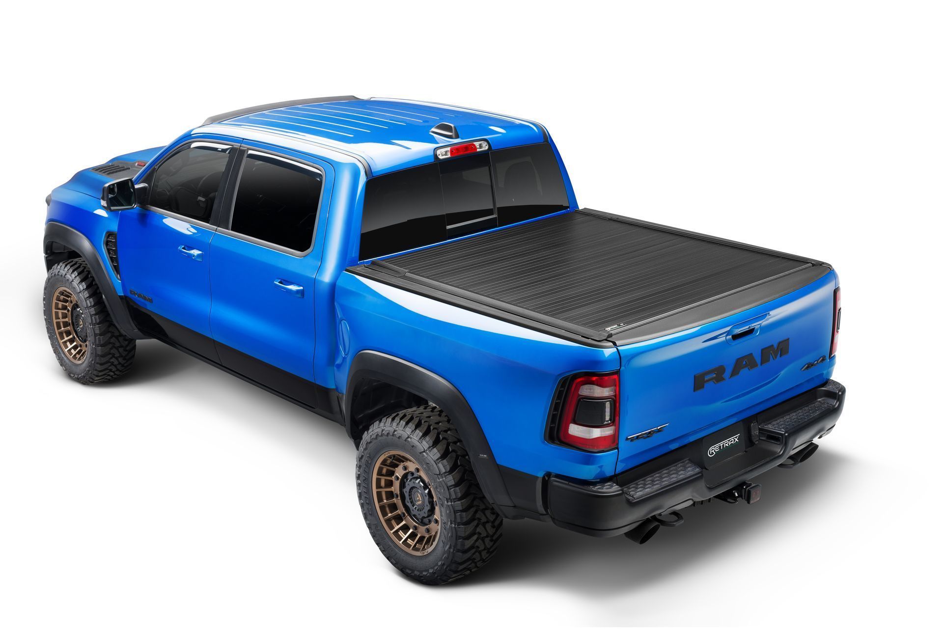 A blue ram truck with a black bed cover on a white background.
