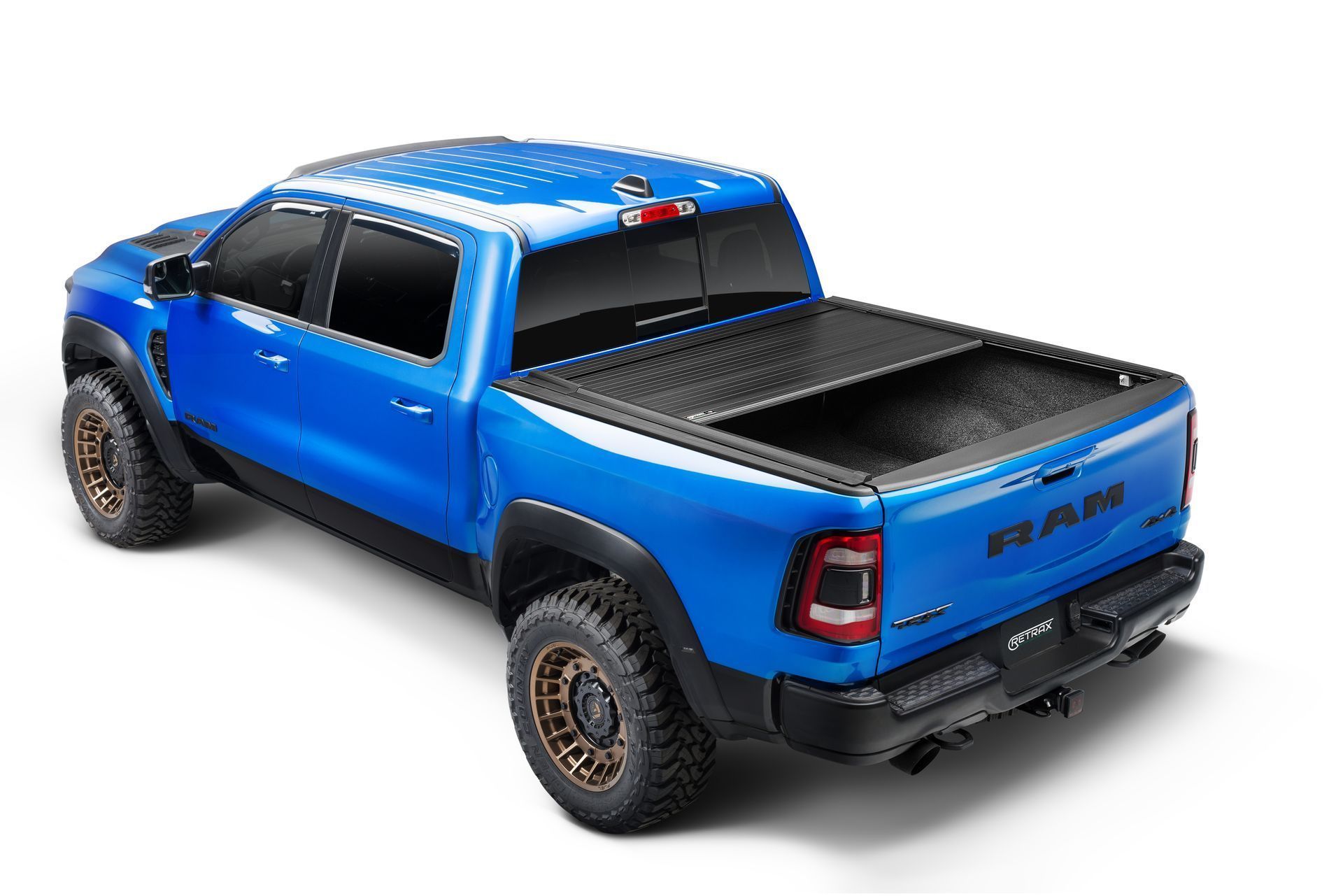 A blue ram truck with a black bed cover on a white background.