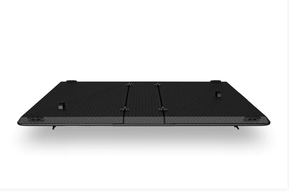 A black mattress is sitting on a white surface.
