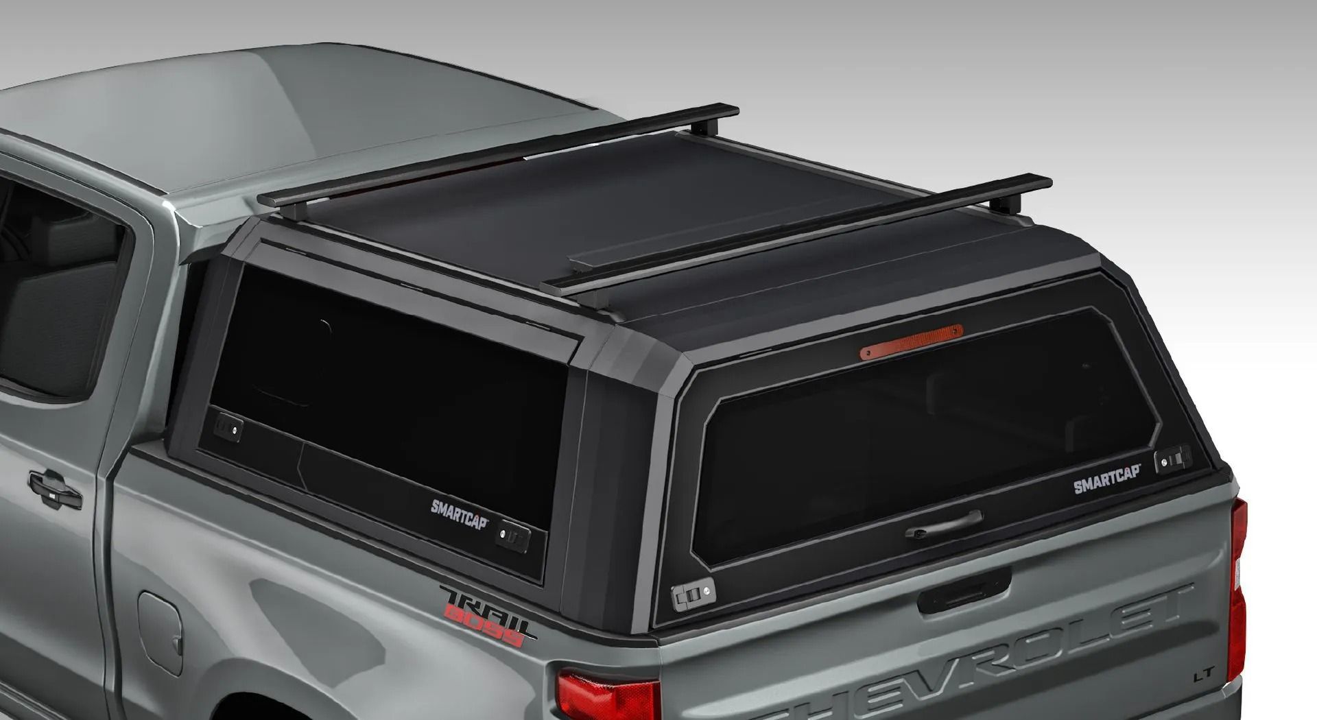 A gray truck with a black canopy on top of it