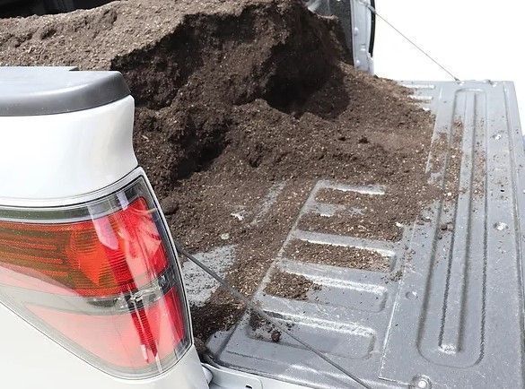 A pile of dirt is sitting in the back of a truck.