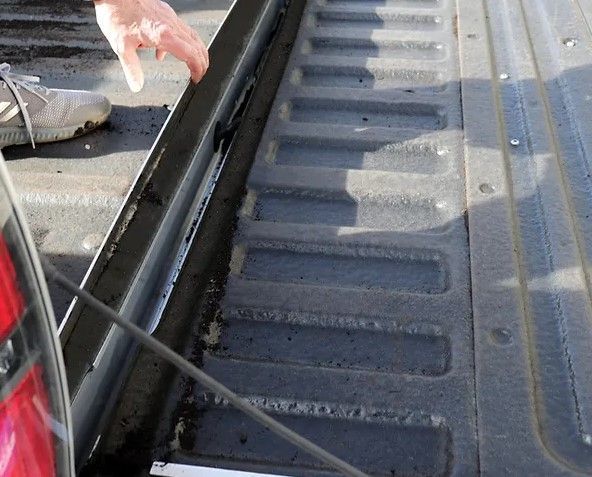 A person is putting something in the back of a truck