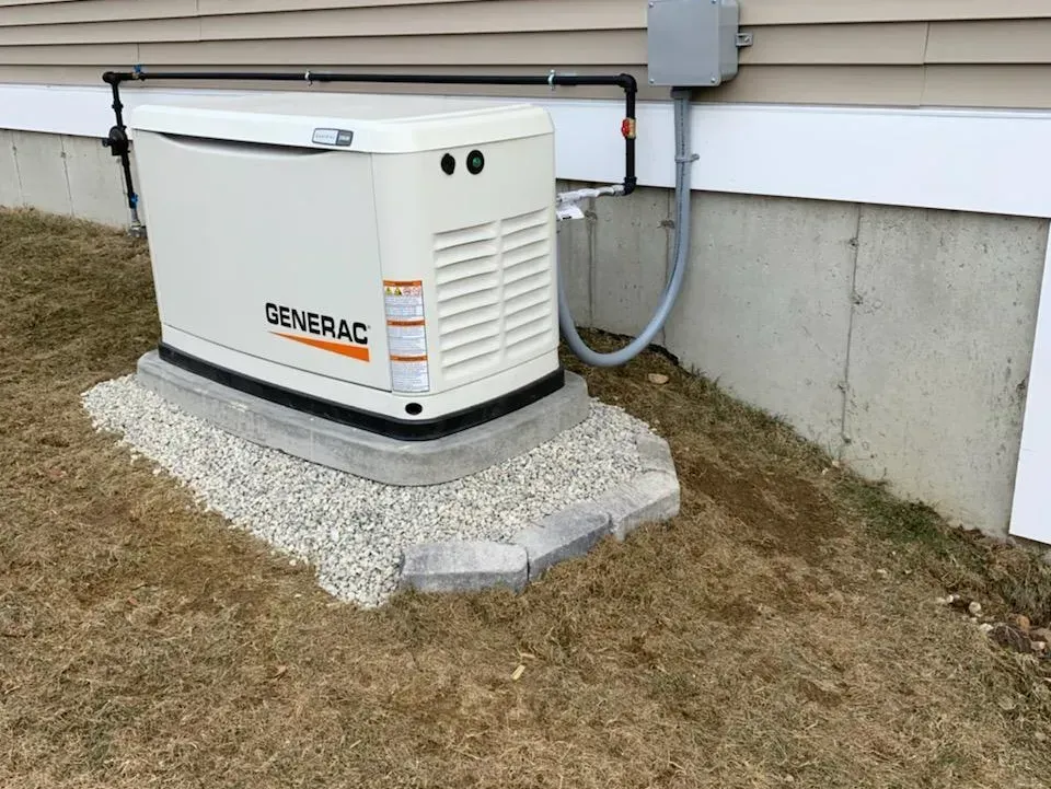A generator is attached to the side of a house.