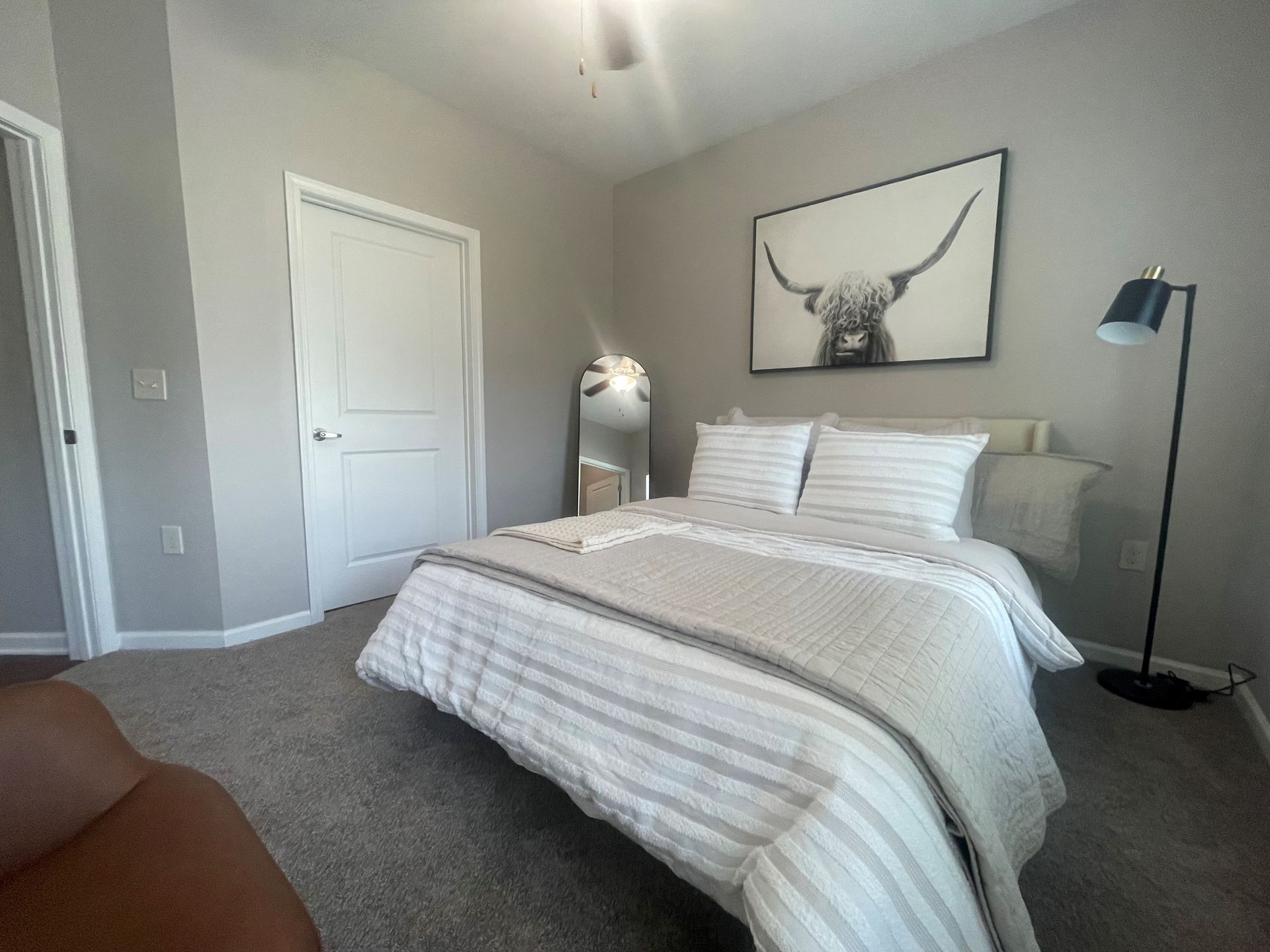 A bedroom with a bed and a picture of a bull on the wall at Thomaston Crossing.
