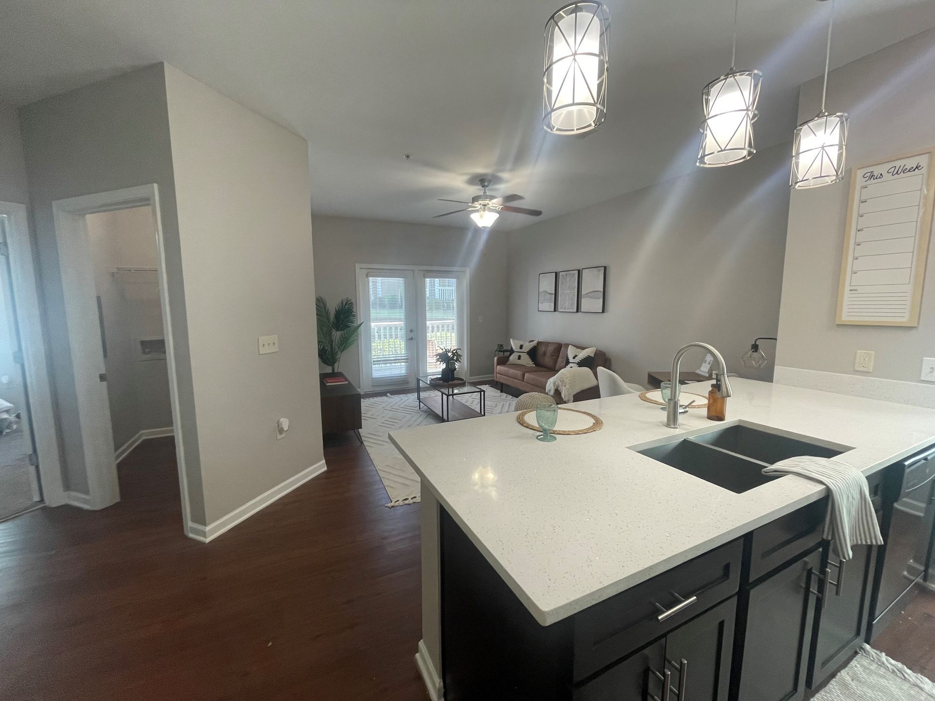 A kitchen with a sink and a living room in the background at Thomaston Crossing.