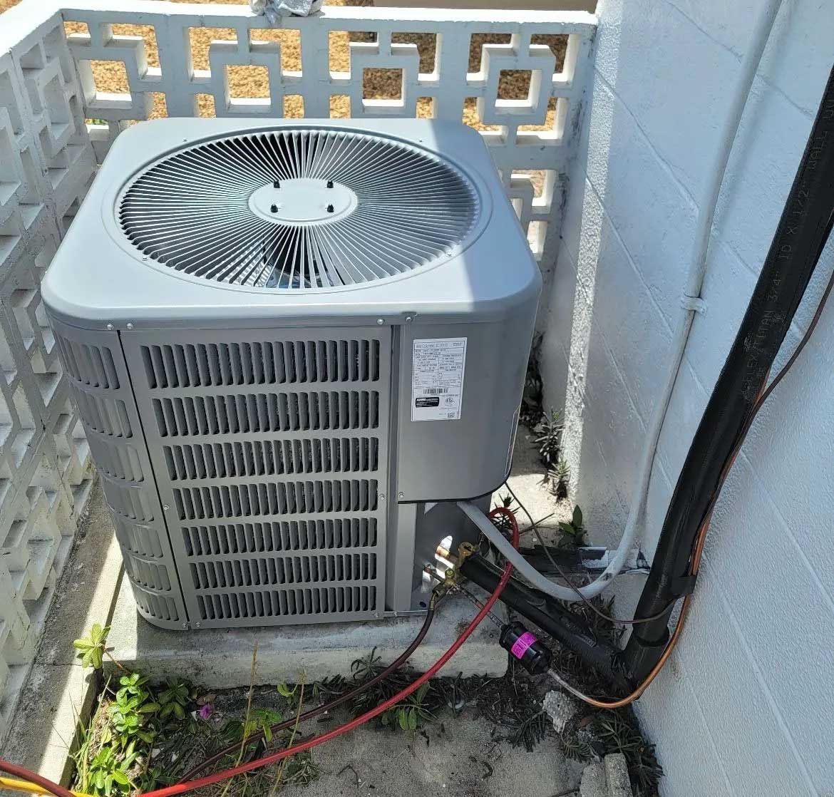 Air conditioner unit near a wall of a modern building on the street in Holiday, FL