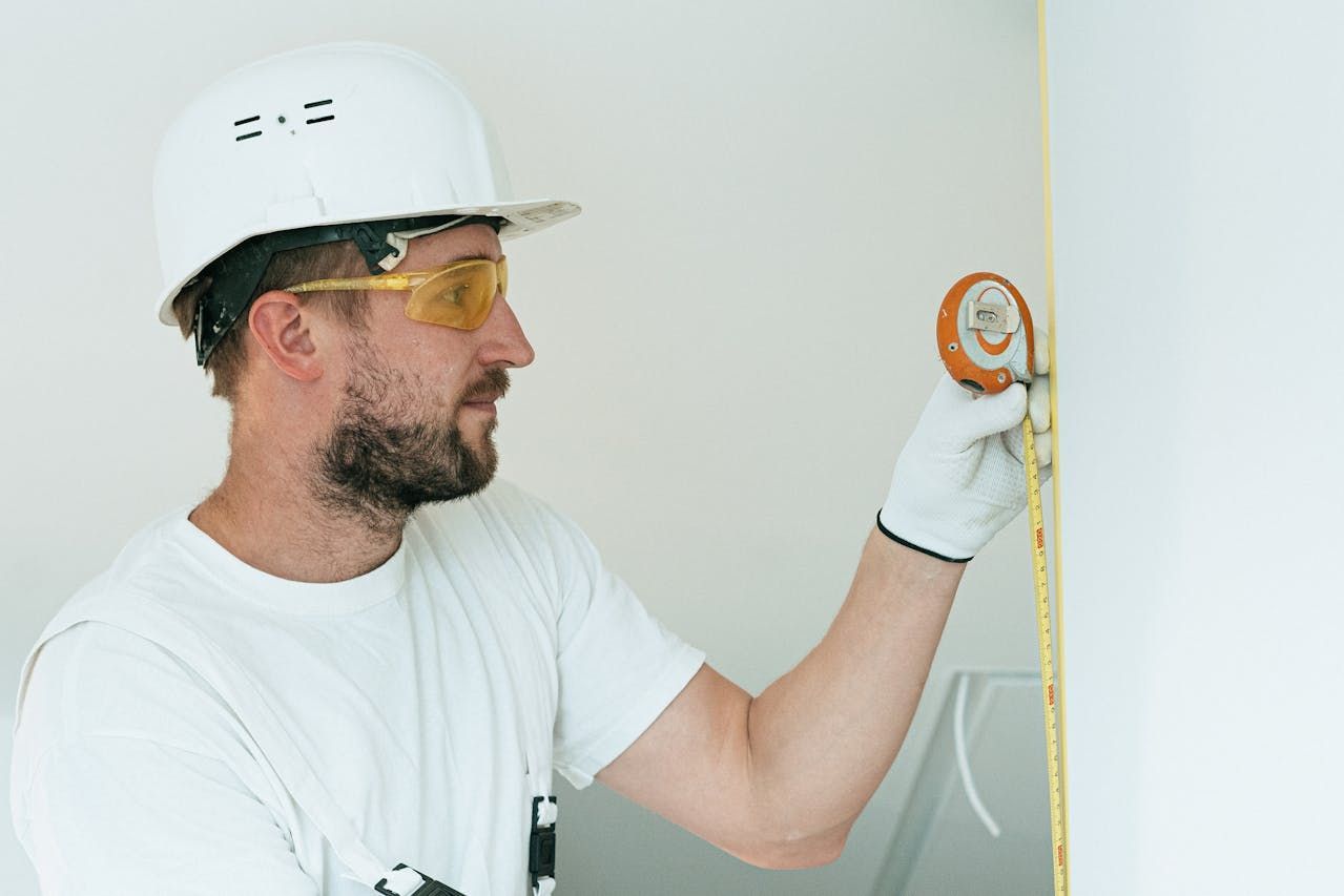 An AC contractor measuring a wall in Holiday, FL
