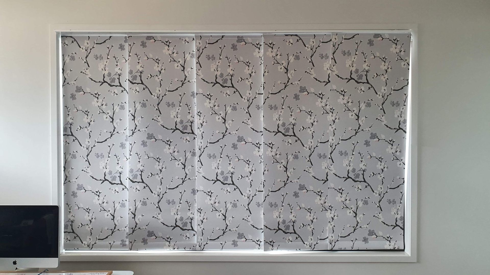 Modern panel glide blinds with floral design installed in a living room window in Brisbane, QLD. Modern panel glide blinds with floral design installed in a living room window in Brisbane, QLD.