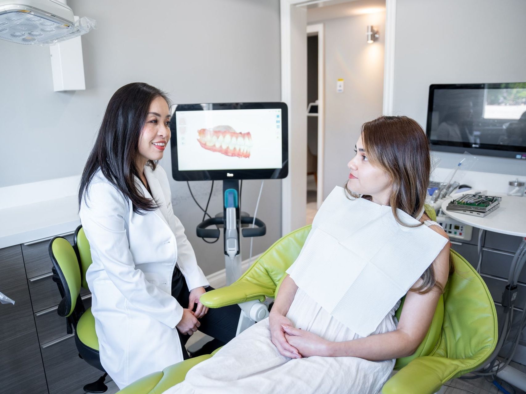 An image of Dr. Han talking to a female patient while showing an iTero dental scan