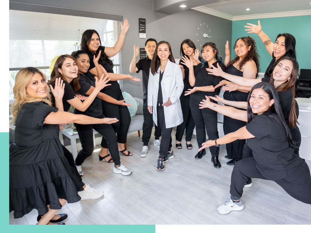 A group shot of the Mint Dental Loft team pointing at Dr. Han in the middle
