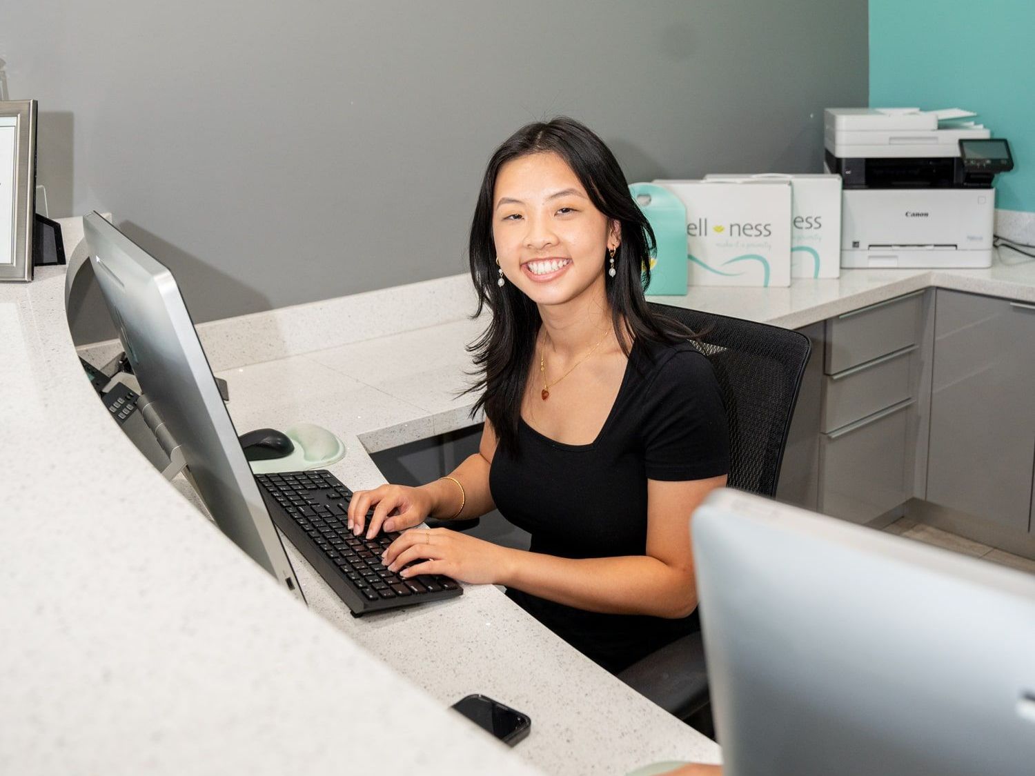 An image of a front desk employee smiling at the camera