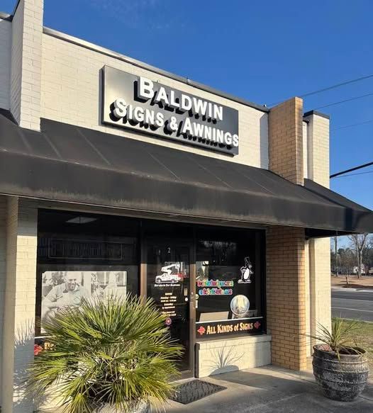 A aldwin signs and awnings store with a black awning