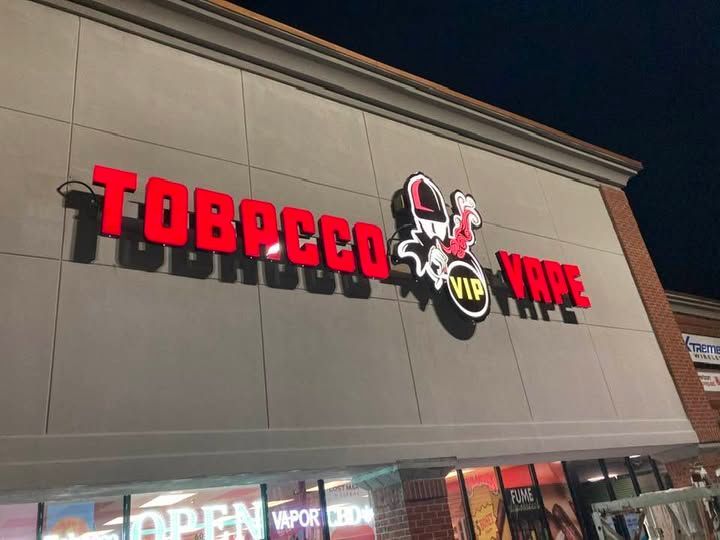 The outside of a tobacco and vape store at night