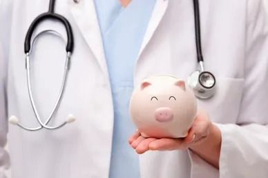 Doctor holding a pink piggy bank, stethoscope around neck.
