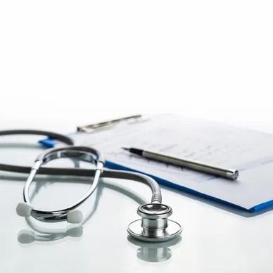 Stethoscope, clipboard with paper, and pen on a white surface, suggesting a medical or healthcare setting.