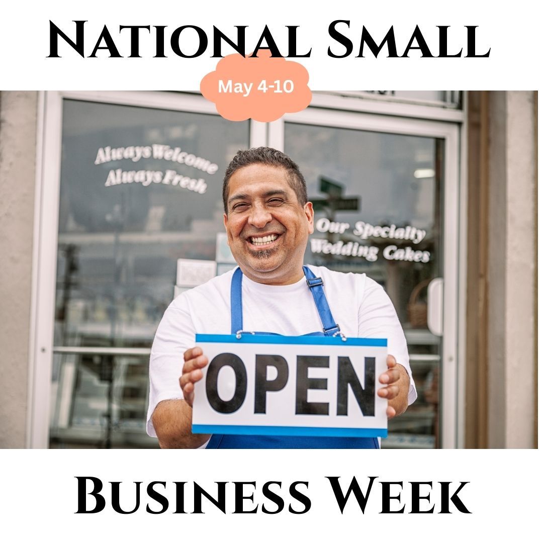A man is holding an open sign in front of a store