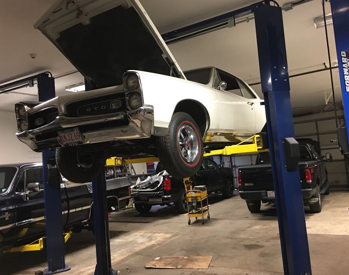 White car in garage with hood up in Melrose, MA | Certified Automotive Solutions