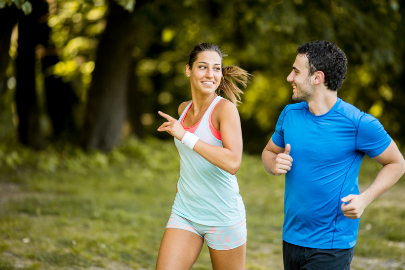 A man and a woman are jogging in a park.