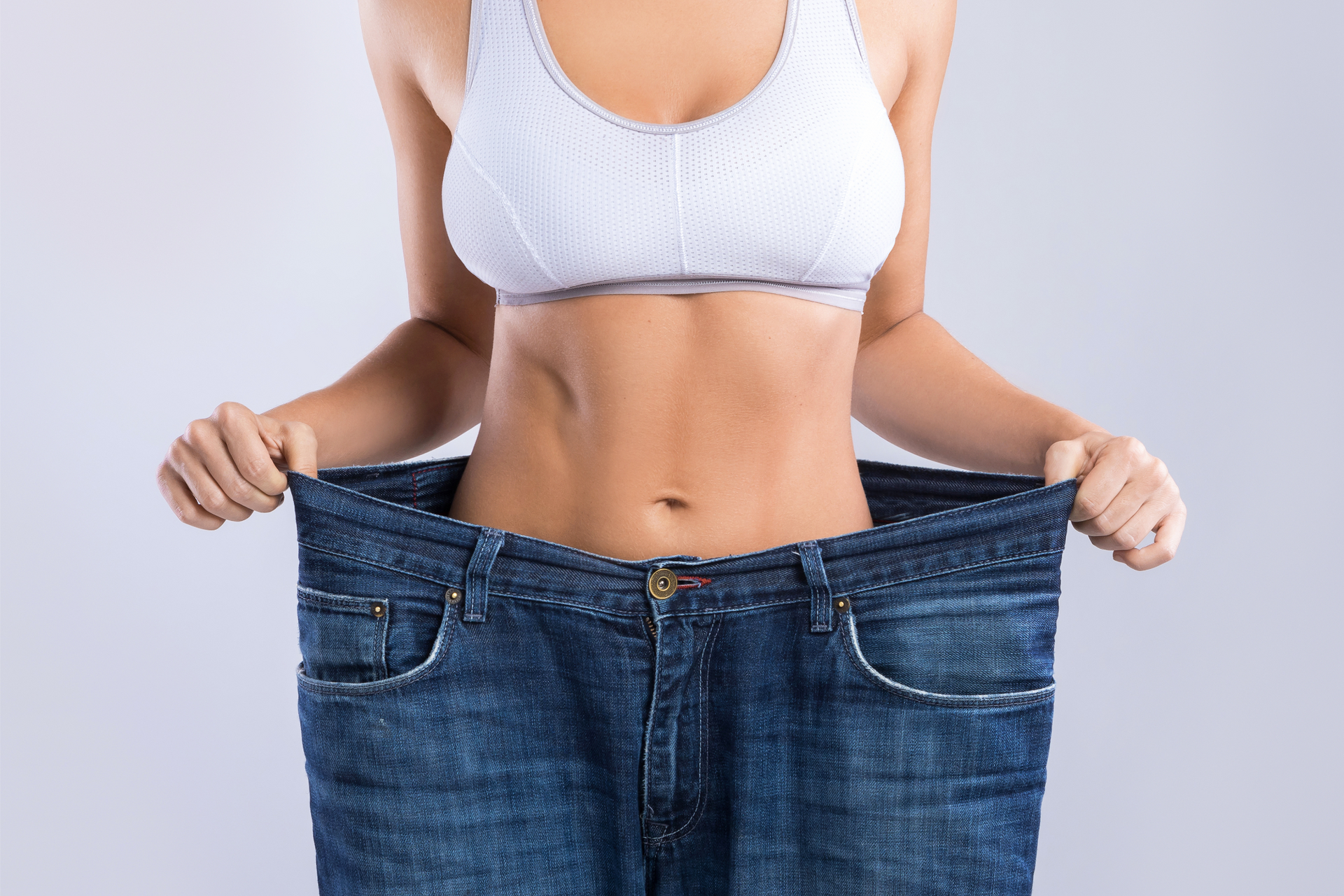 A woman is wearing a pair of very large jeans.