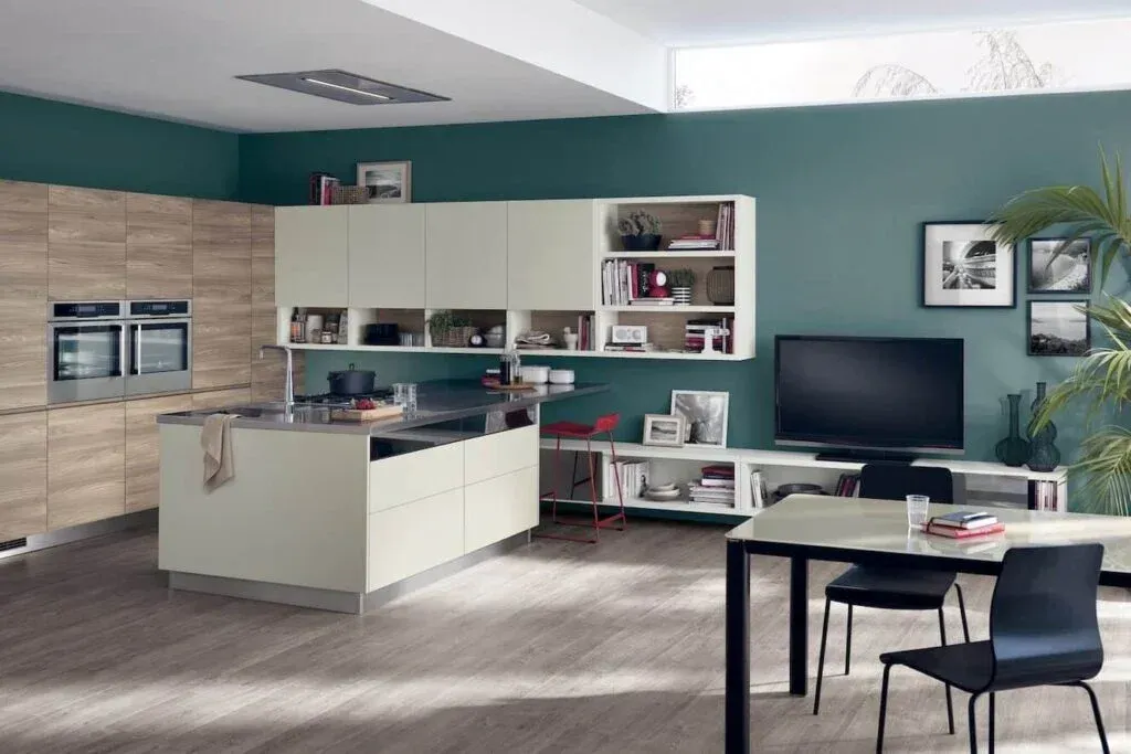 Modern kitchen with island, cabinets, dining area, and teal accent wall.