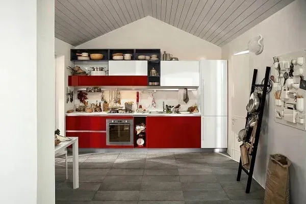 Modern red and white kitchen with gray floor and a pitched ceiling.