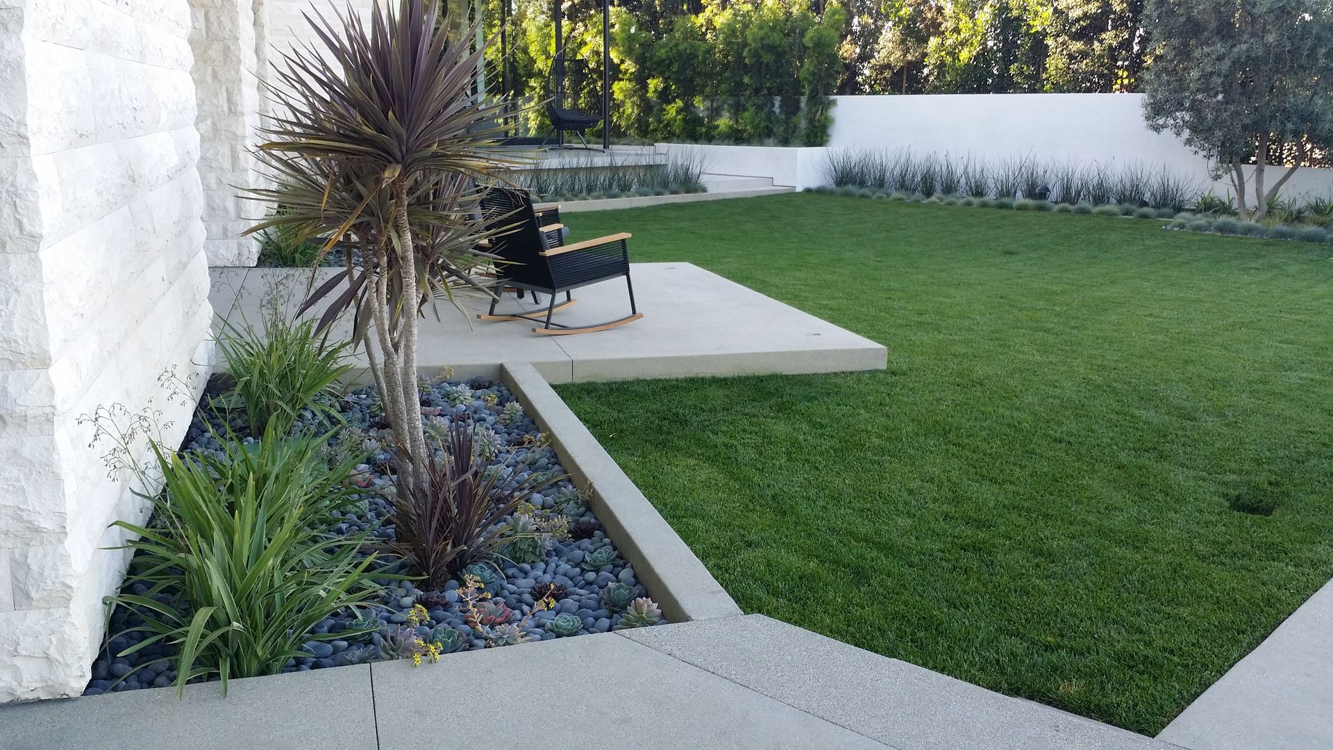 A lawn with a rocking chair in the middle of it