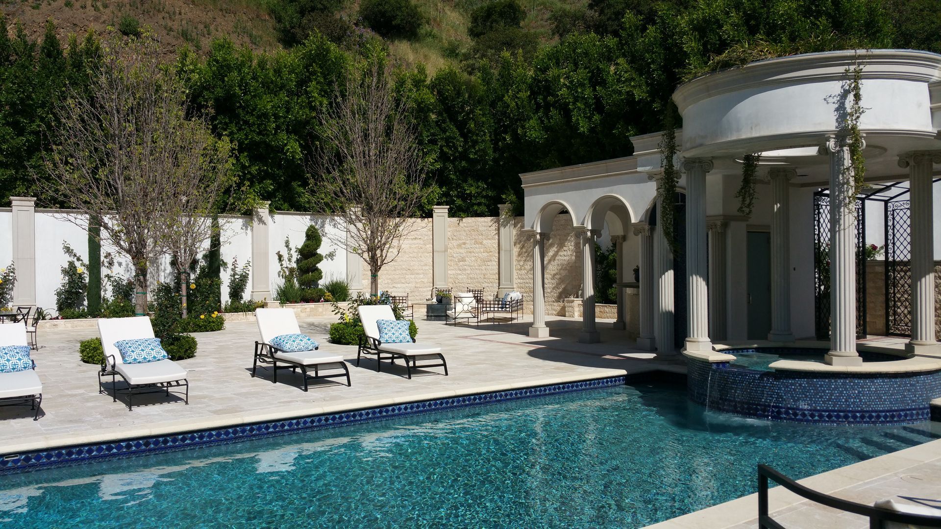 A large swimming pool with a gazebo in the background