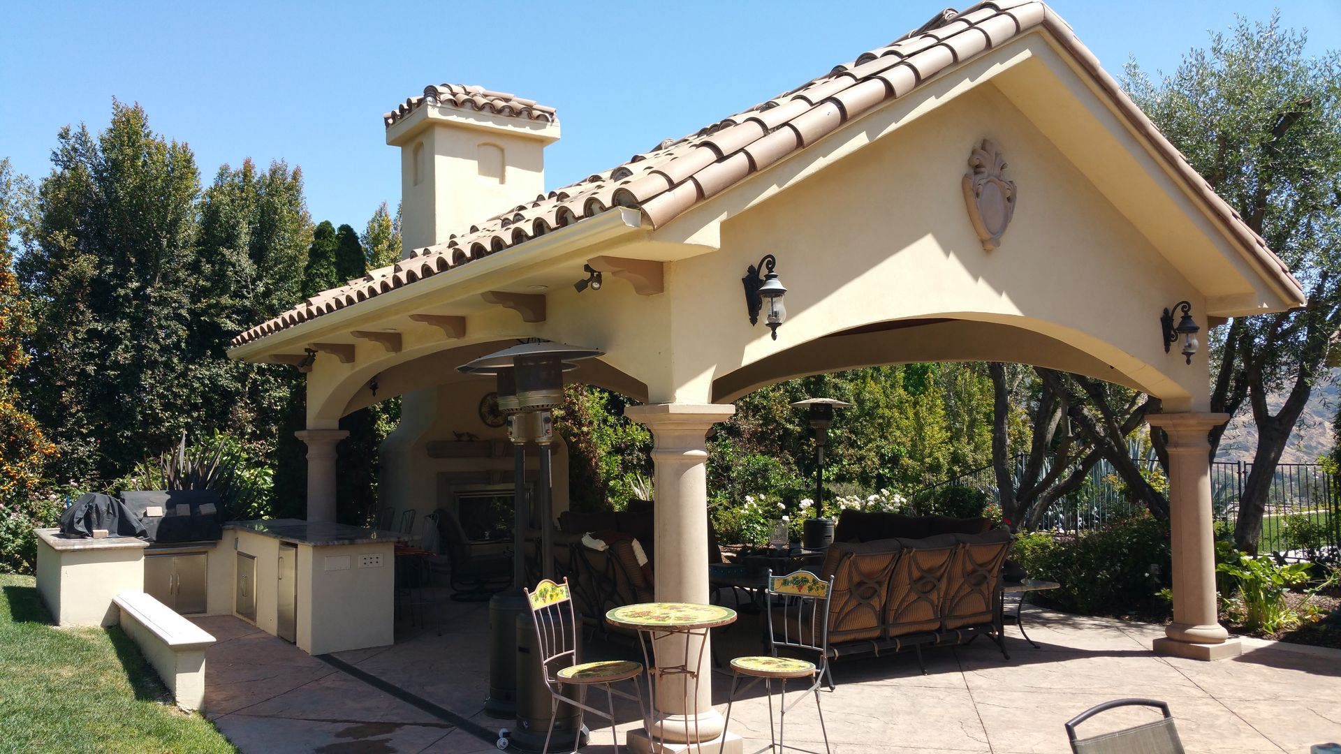 A covered patio area with tables and chairs under a roof