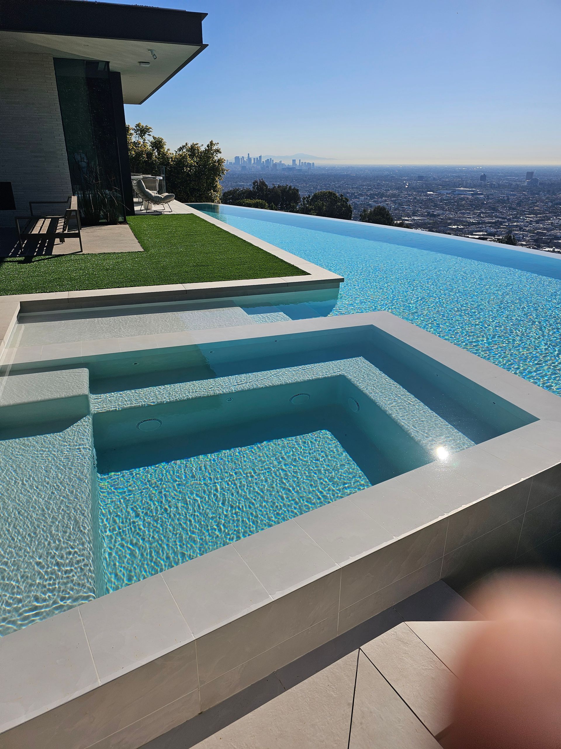 A large swimming pool with a view of the city