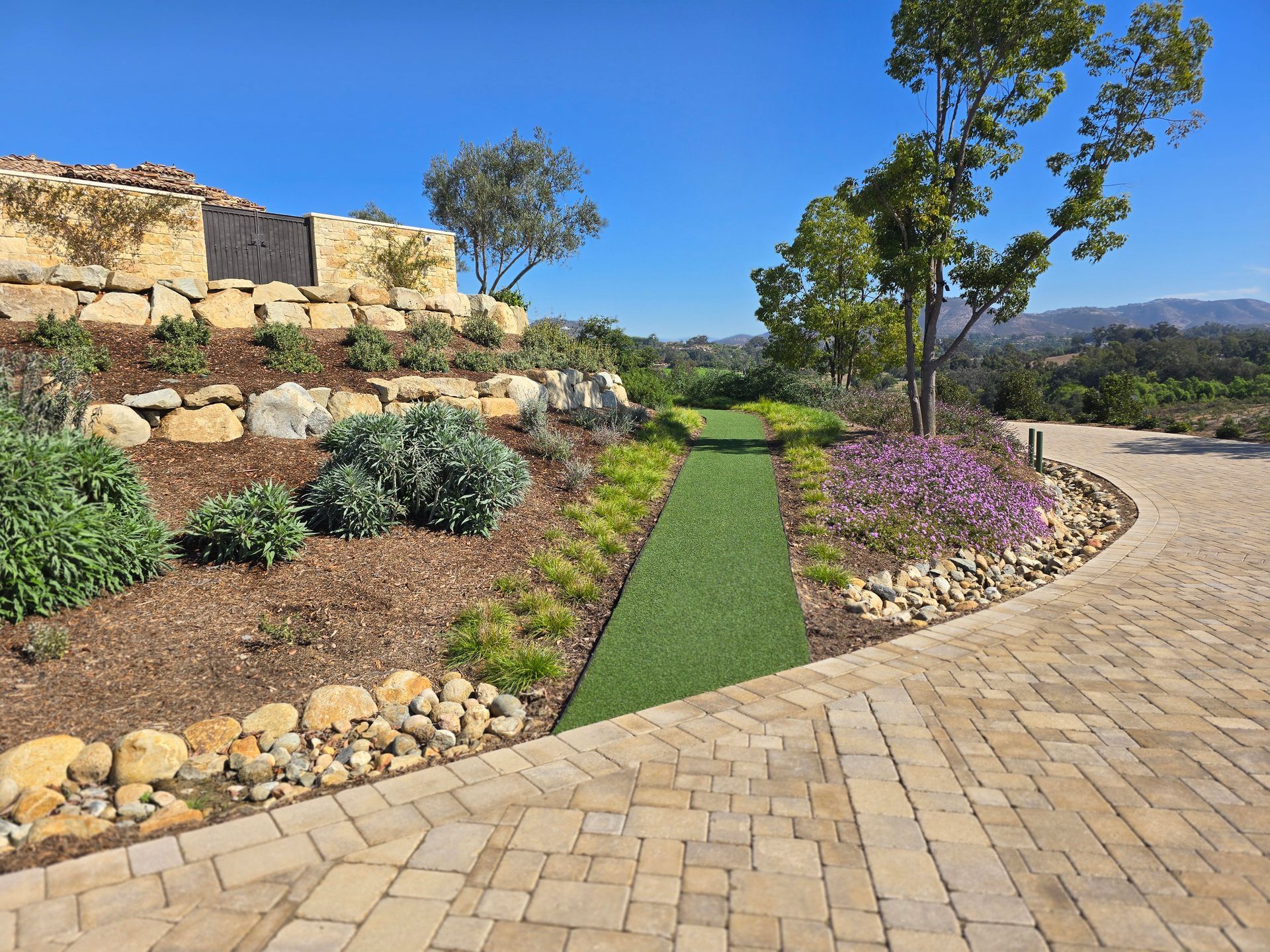 A brick driveway with a grassy path going through it