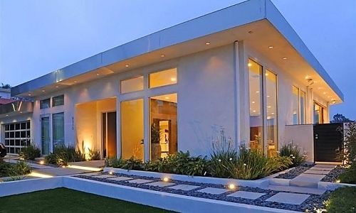 A white house with a lot of windows is lit up at night