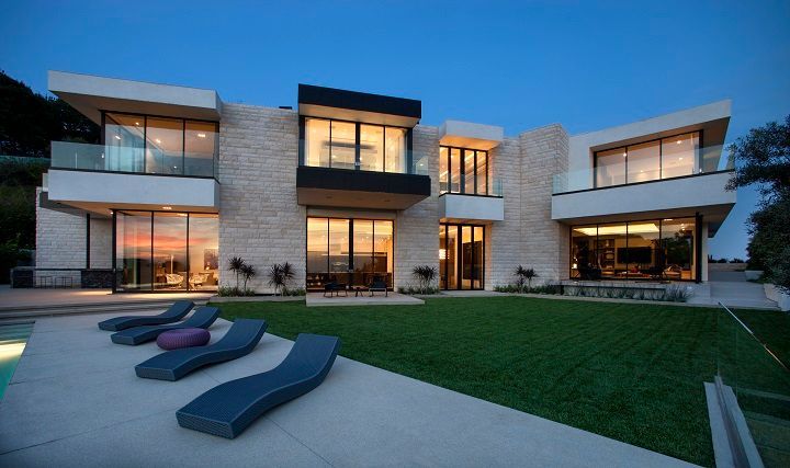 A large house with a lot of windows and lawn chairs in front of it