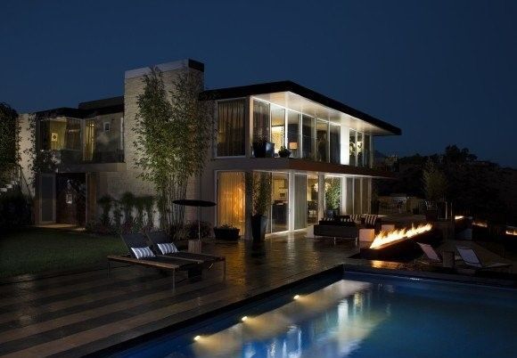 A large house with a swimming pool in front of it