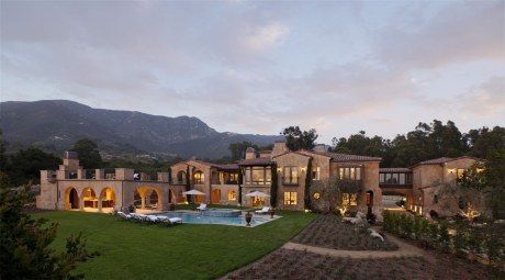 A large house with a pool and mountains in the background