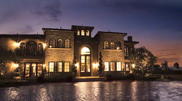 A large house with a lot of windows is lit up at night